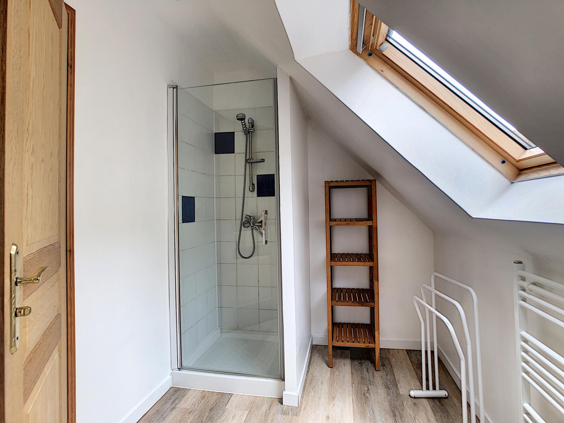 Salle d'eau avec meuble vasque, cabine de douche et sèche-serviettes